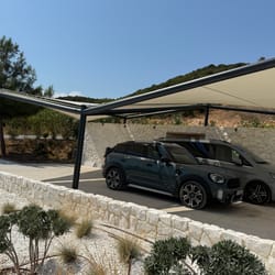 Ελαφριά μεταλλική κατασκευή για σκίαστρο στάθμευσης, φωτογραφημένη από απόσταση στη Νέα Πέραμο